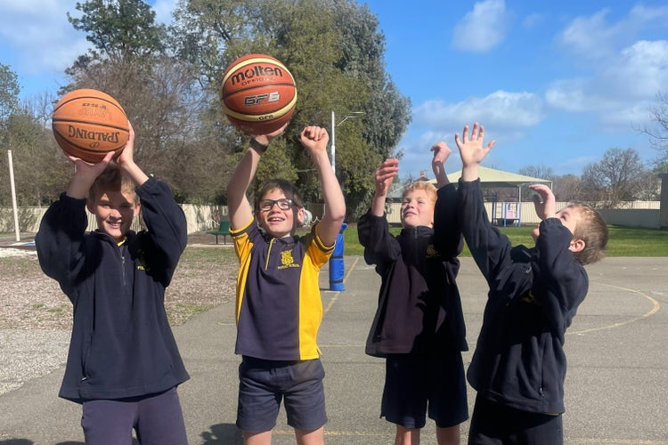 Three students completing basketball skills during a coaching clinic
